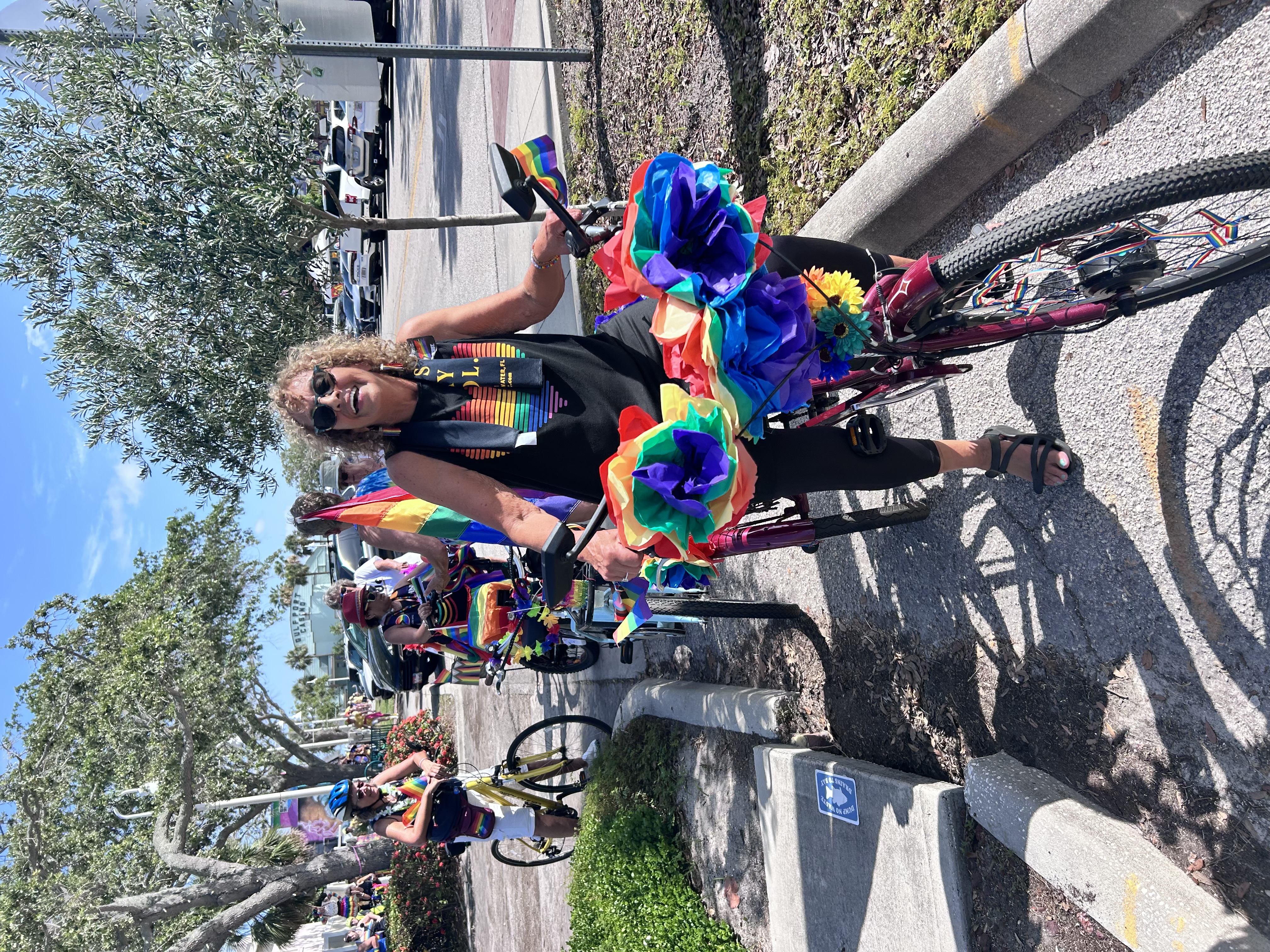 Pride participant with rainbow decorations and flowers at Gulfport Pride